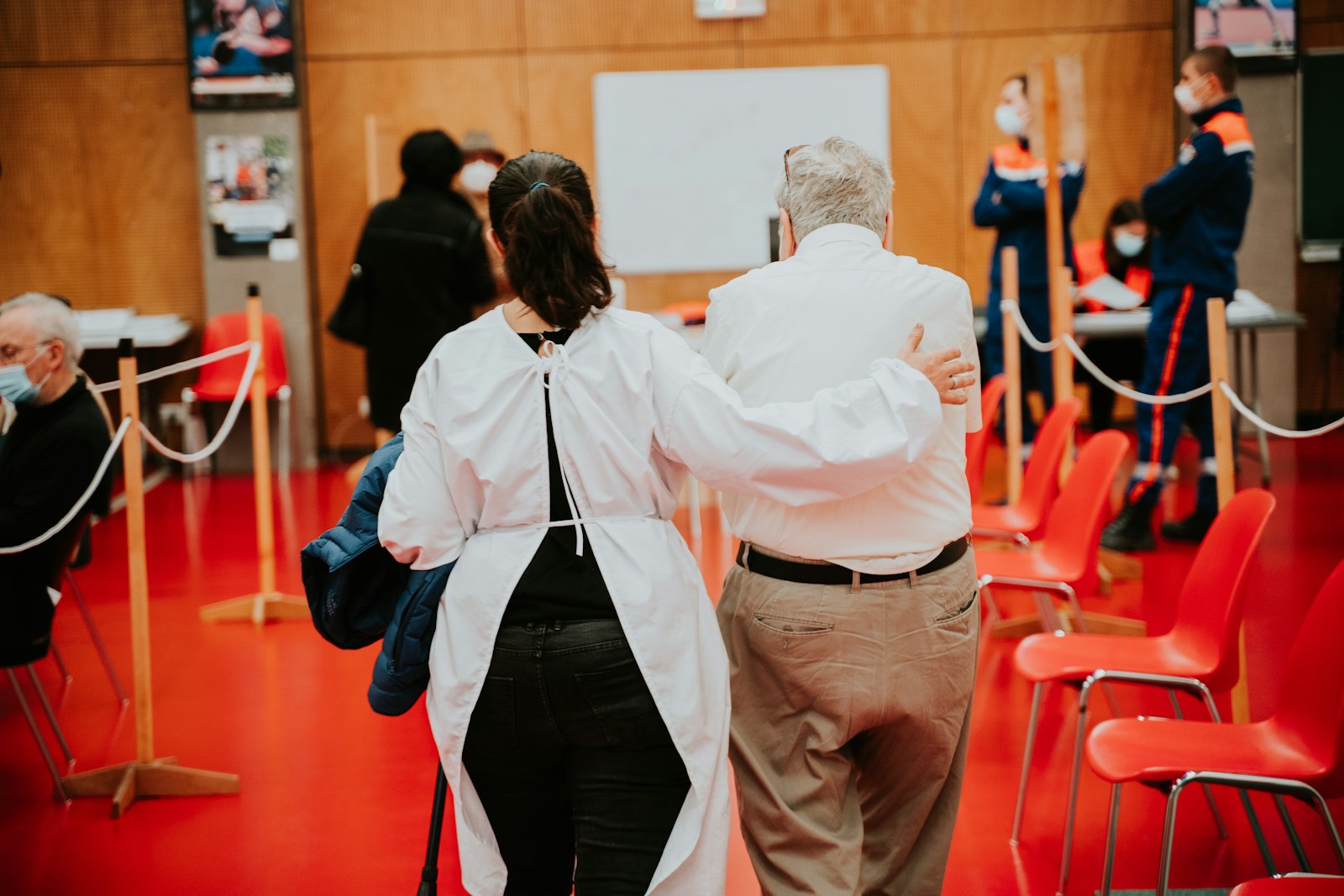 man in white dress shirt and red pants standing beside woman in white dress shirt